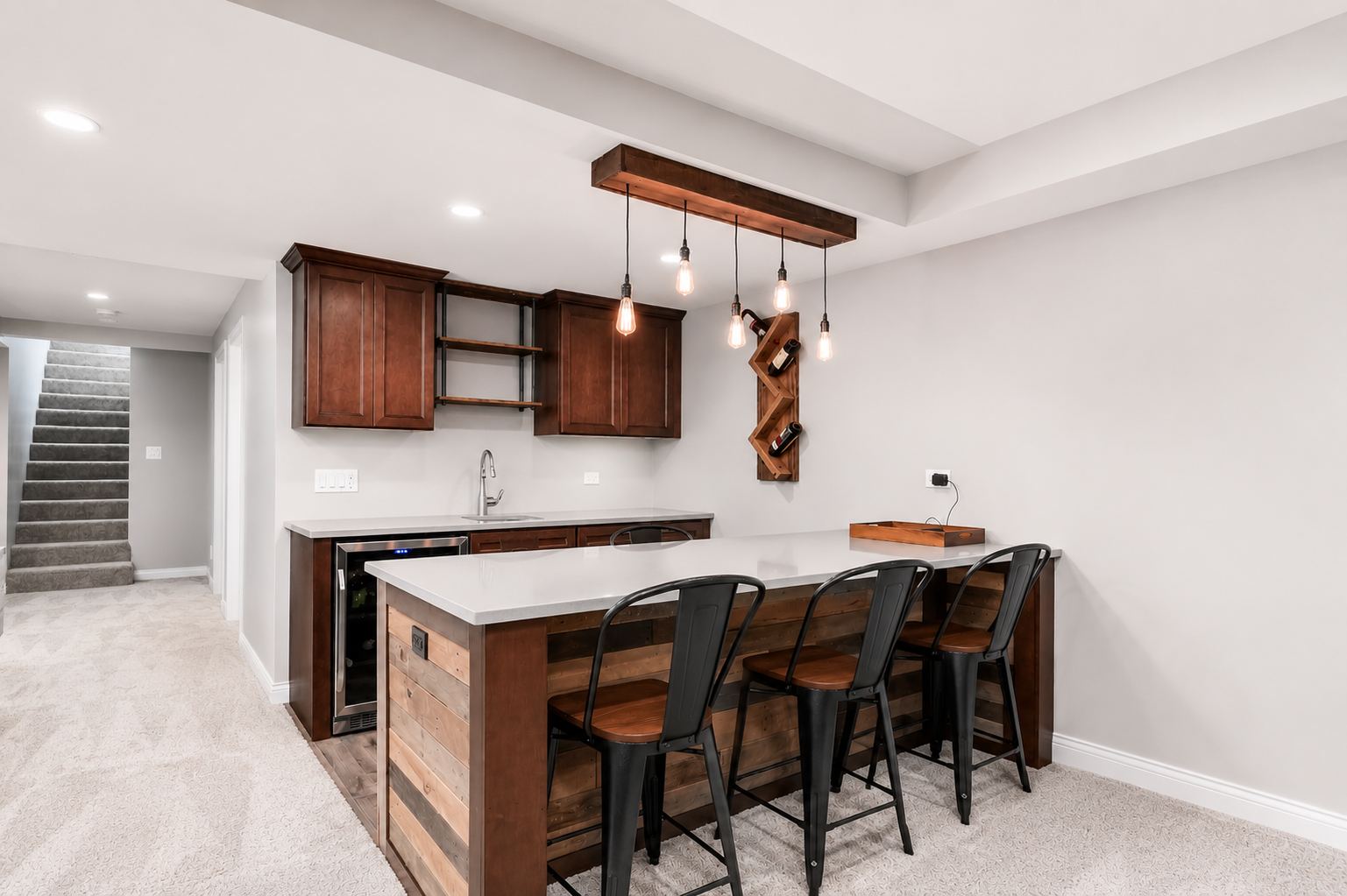 Custom basement bar with reclaimed wood island and pendant lighting, remodeled by Corinth Basement Remodeling in Brookfield, WI