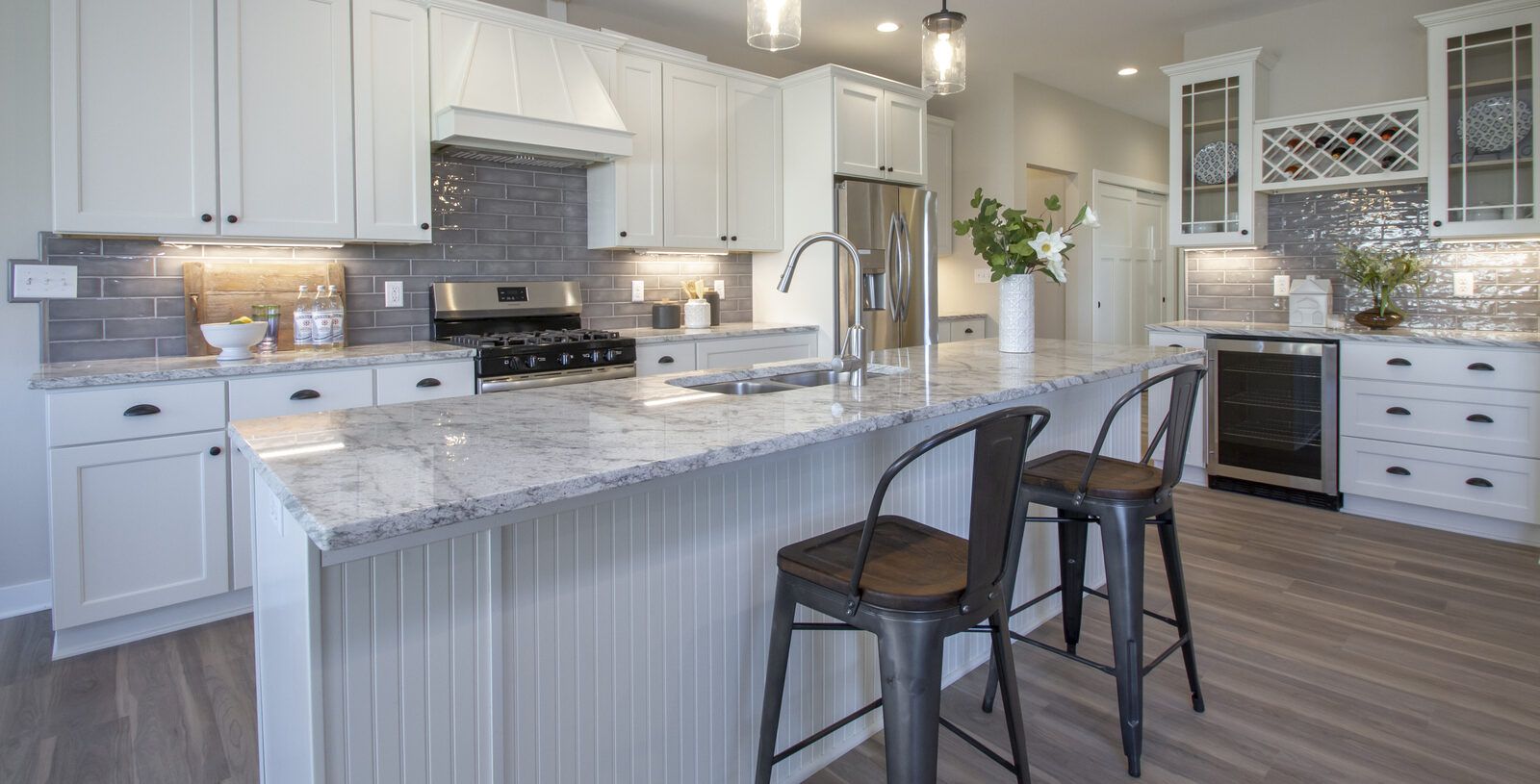 Kitchen remodel with island seating and built-in wine cooler by Corinth